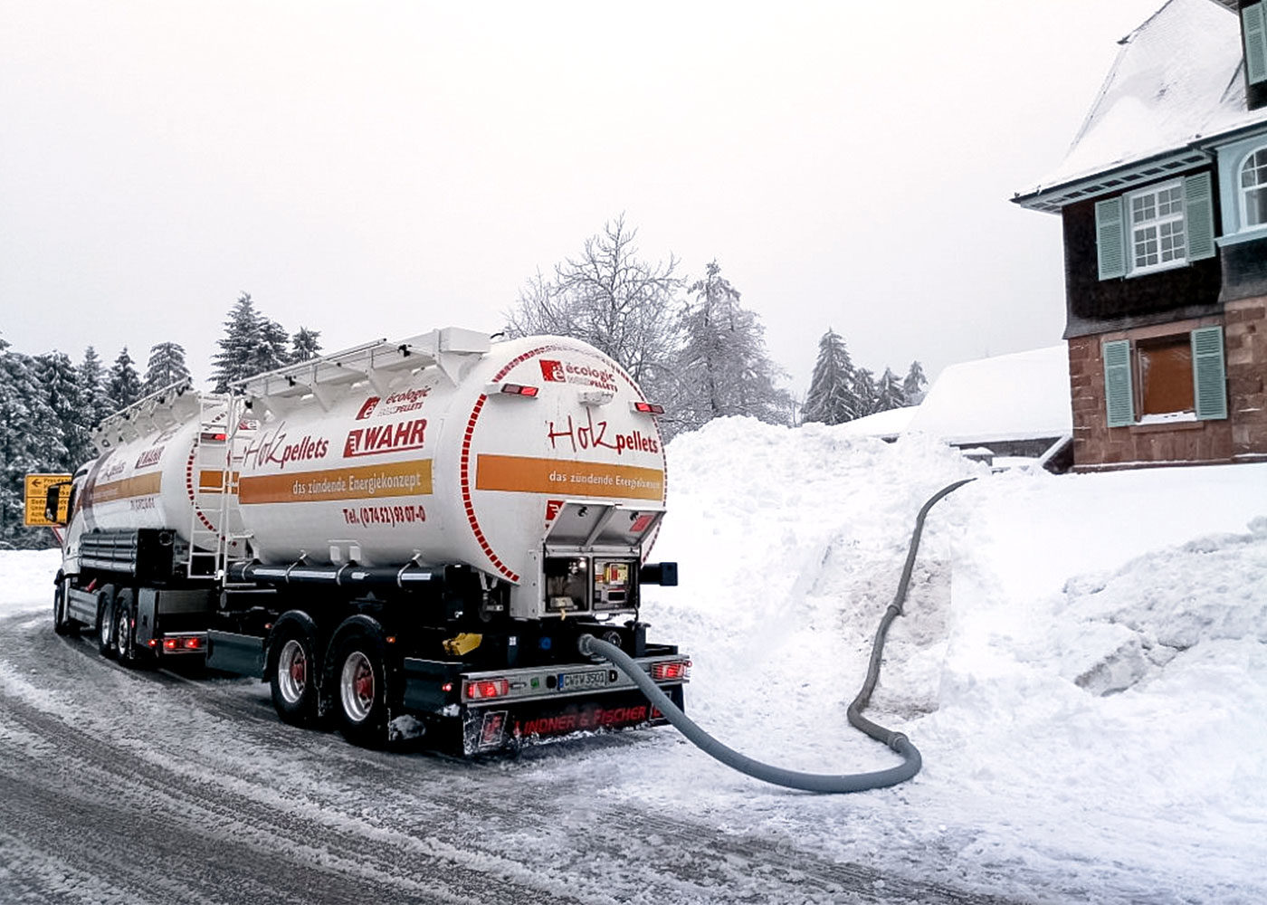 Bild eines Pellet LKWs, welcher im Winter bei Schnee neue Pellets anliefert.