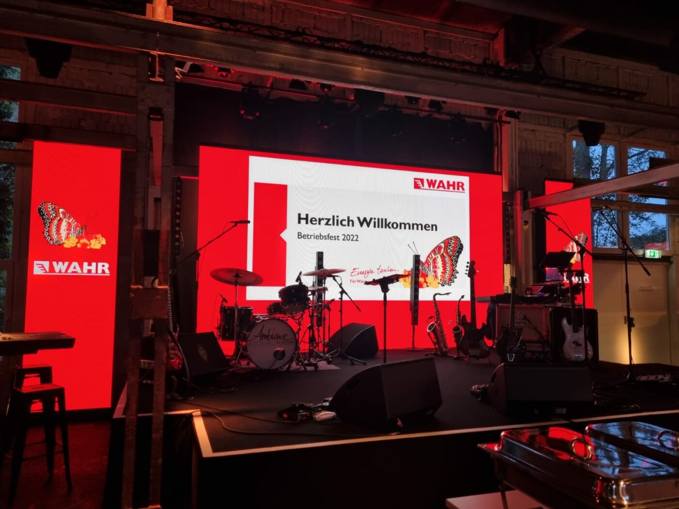 Fritz Wahr Energie Betriebsfest 2022 Bühne mit Musikinstrumenten und PowerPoint-Präsentation